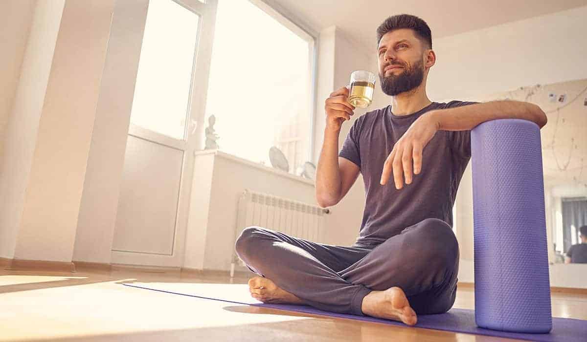 Homem praticando Yoga e bebendo Chá